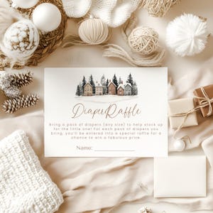 May include: A baby shower invitation with the text "Diaper Raffle" and a watercolor illustration of houses in a snowy landscape. The invitation is surrounded by decorative elements like ornaments, pinecones, and wrapped gifts.