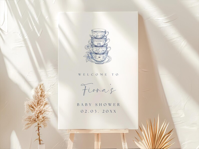 May include: A white welcome sign with blue text and a blue and white illustration of a stack of teacups. The text reads "Welcome to Fiona's Baby Shower 02.03.20XX".