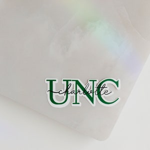 May include: Green and white sticker with the text "UNC charlotte" in a bold, blocky font.