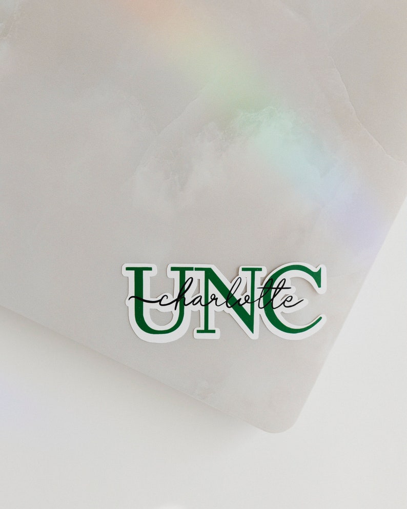 May include: Green and white sticker with the text "UNC charlotte" in a bold, blocky font.