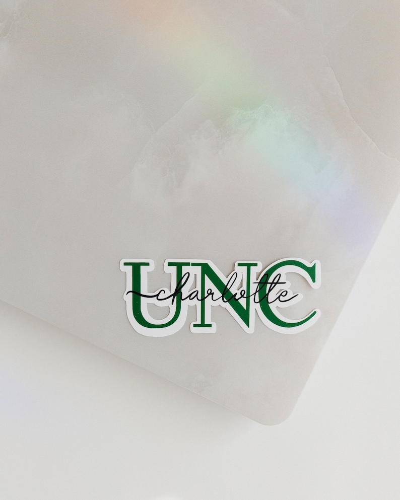 May include: Green and white sticker with the text "UNC charlotte" in a bold, blocky font.