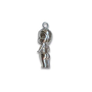 K&ouml;nnte beinhalten: Ein silberfarbener Anh&auml;nger in Form einer stilisierten Figur mit rundem Kopf, kleinen Armen und einem abgerundeten Unterteil. Der Anh&auml;nger hat oben eine Schlaufe zum Befestigen an einer Halskette oder einem Armband. Die Figur steht aufrecht.