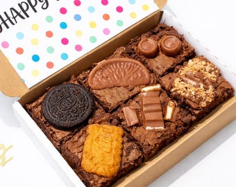 May include: A box of assorted brownies with various toppings, including an Oreo cookie, chocolate orange slice, and a Biscoff cookie. The box includes a card that says "HAPPY BIRTHDAY" with colorful polka dots.