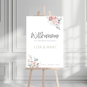 Könnte beinhalten: Ein weißes Willkommensschild mit floralen Akzenten in Rosa- und Grüntönen. Das Schild trägt die Aufschrift "Willkommen zu unserer Hochzeit Lisa & Marc" und "12. August 2023".