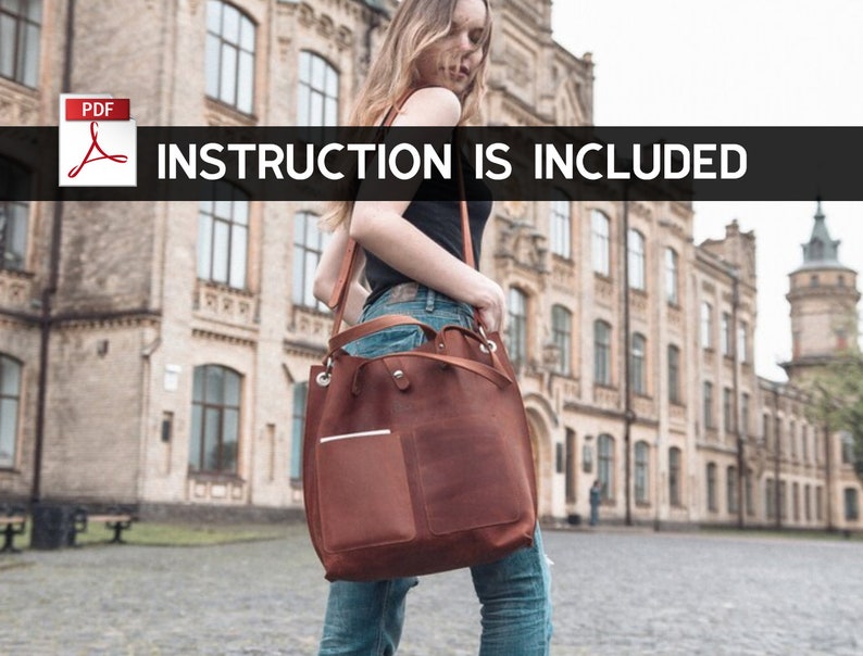 Puede incluir: Un bolso tote de cuero marr&oacute;n con un bolsillo con cremallera en la parte delantera. El bolso tiene una correa larga y lo lleva una persona en un entorno urbano. INSTRUCTION IS INCLUDED.
