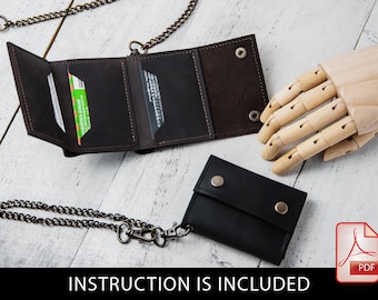 May include: Two leather wallets with a chain attached. One wallet is brown and the other is black. Both wallets are closed and have a flap with a snap closure. The wallets are on a white wooden surface.  INSTRUCTION IS INCLUDED.