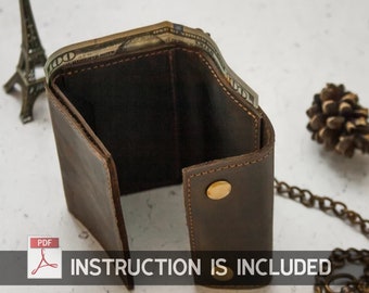 May include: A brown leather wallet with a chain attached. The wallet is open and has cash inside. The text "INSTRUCTION IS INCLUDED" is visible at the bottom of the image.