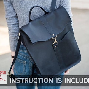 May include: A dark blue leather backpack with a flap closure and a gold metal buckle. The backpack has a large pocket on the front and a smaller pocket on the side.  INSTRUCTION IS INCLUDED.