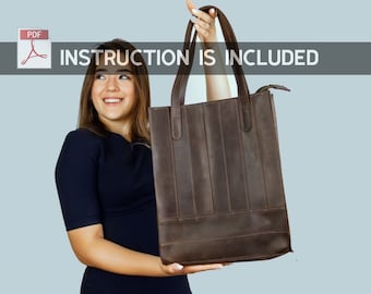 May include: A woman holds a brown leather tote bag with a zipper closure. The bag has a structured design with vertical stitching. The text "INSTRUCTION IS INCLUDED" is displayed above the bag.