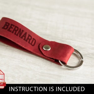 May include: Red leather keychain with a silver key ring and the name "BERNARD" embossed in red.