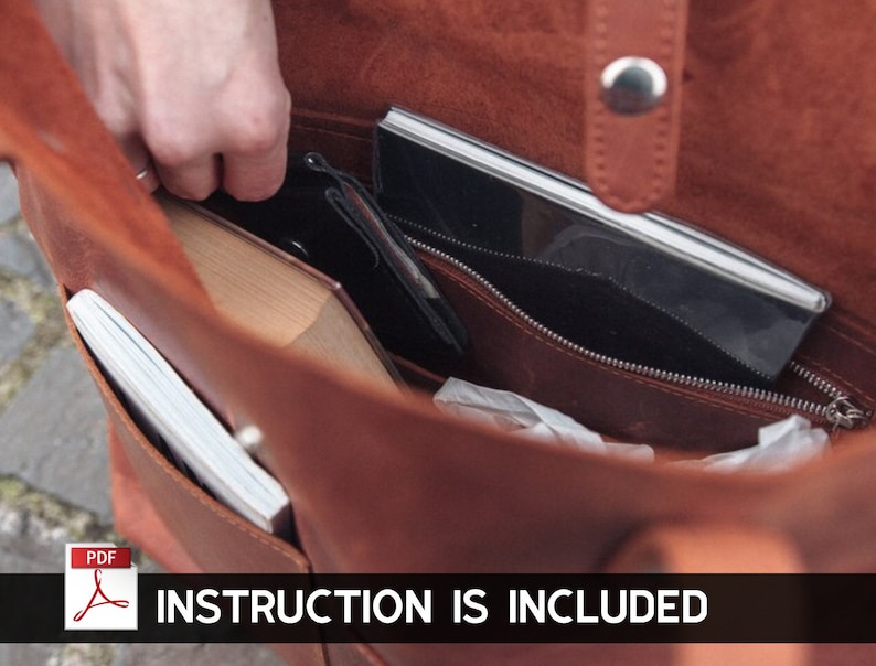 Puede incluir: Un bolso tote de cuero marr&oacute;n con un bolsillo con cremallera y un cierre de solapa. El bolso est&aacute; abierto y se puede ver el interior, que est&aacute; forrado con una tela de color claro. Hay varios art&iacute;culos dentro del bolso, incluyendo un cuaderno, un tel&eacute;fono y un libro. El texto "INSTRUCTION IS INCLUDED" est&aacute; impreso en la parte inferior de la imagen.