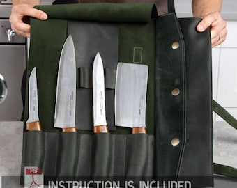 May include: A green leather knife roll with five slots for knives. The roll has a flap that folds over and secures with a snap. The roll is open and shows five knives, including a chef's knife, a paring knife, and a cleaver. The text "INSTRUCTION IS INCLUDED" is printed on the bottom of the roll.