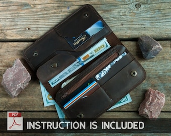 May include: A brown leather wallet with multiple compartments, including a zippered pocket, is open to reveal cash, credit cards, and a blue card. The wallet is lying on a wooden surface.