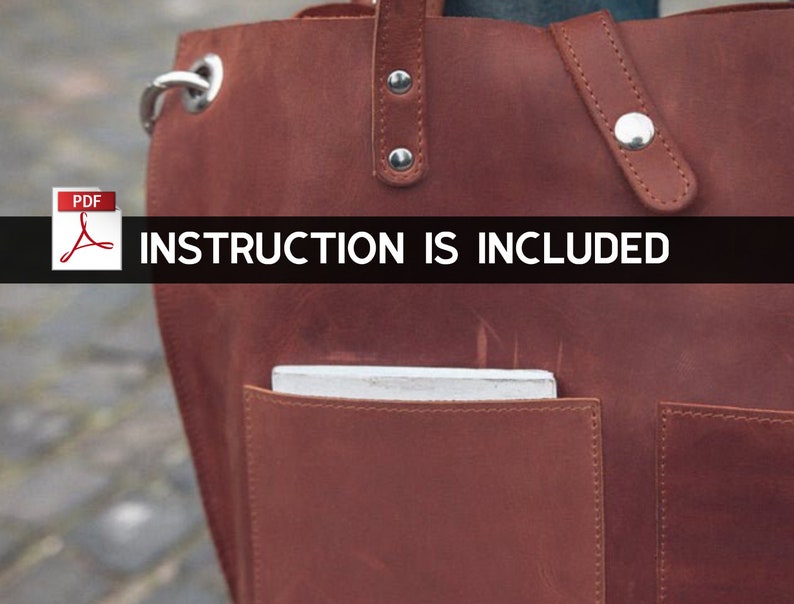 Puede incluir: Un bolso tote de cuero marr&oacute;n con un bolsillo con cremallera y un cierre de solapa. El bolso tiene un papel blanco dentro del bolsillo. El texto "INSTRUCTION IS INCLUDED" est&aacute; impreso en una pancarta negra.