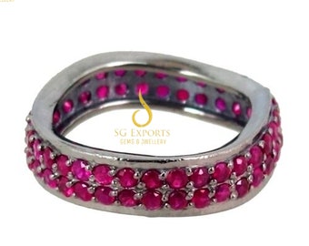 May include: A silver ring with two rows of pink ruby stones. The ring is square shaped and has the text "SG Exports Gems & Jewellery" on the inside.