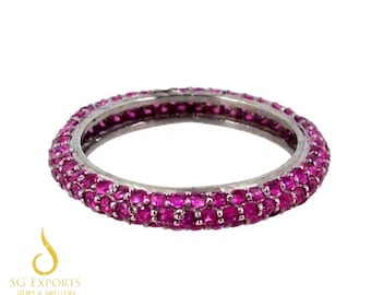 May include: A silver band ring with a double row of pink ruby stones.
