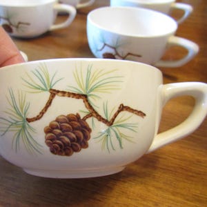 May include: A set of three ceramic mugs with a speckled, matte finish. The mugs are in shades of blue, green, and white. Each mug has a simple, modern design, perfect for coffee or tea. The mugs are likely handmade.