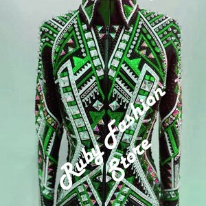 May include: A black long-sleeve jacket featuring vibrant green geometric patterns, silver metallic accents, and numerous clear crystals. The front includes a central zipper closure and the text "Green on Black Base" and "Ruby Fashion Store".