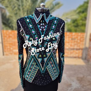 May include: A black long-sleeve show shirt featuring intricate geometric patterns in teal, silver, and iridescent crystals. The garment includes a structured collar, a front zipper, and dense beadwork. The text Ruby Fashion Store Etsy is overlaid.