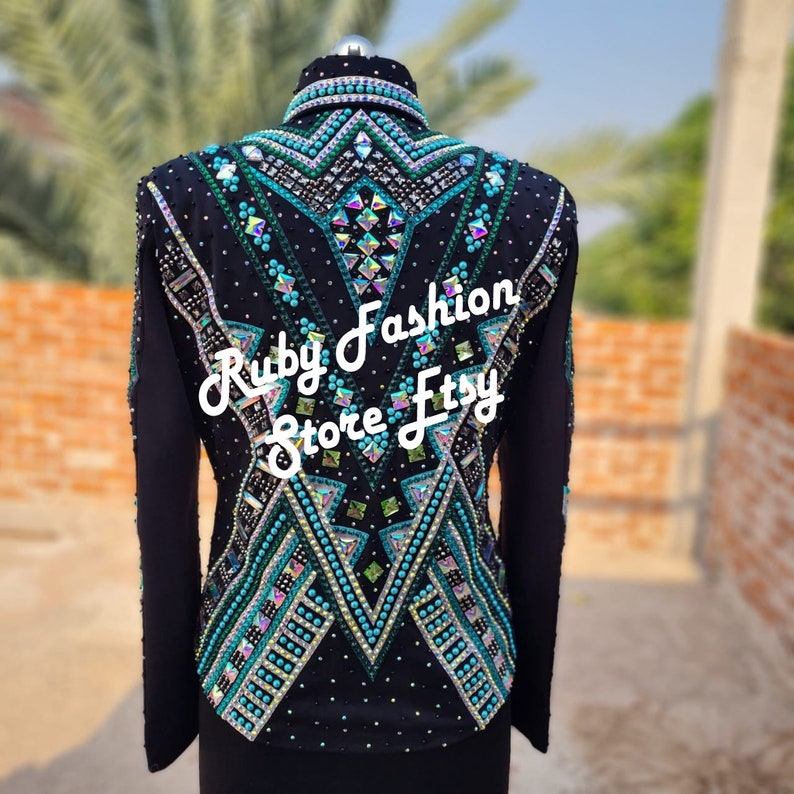 May include: A black long-sleeve jacket featuring intricate geometric patterns of turquoise beads, clear crystals, and iridescent rhinestones. The back displays a symmetrical design with the white text Ruby Fashion Store Etsy overlaid.