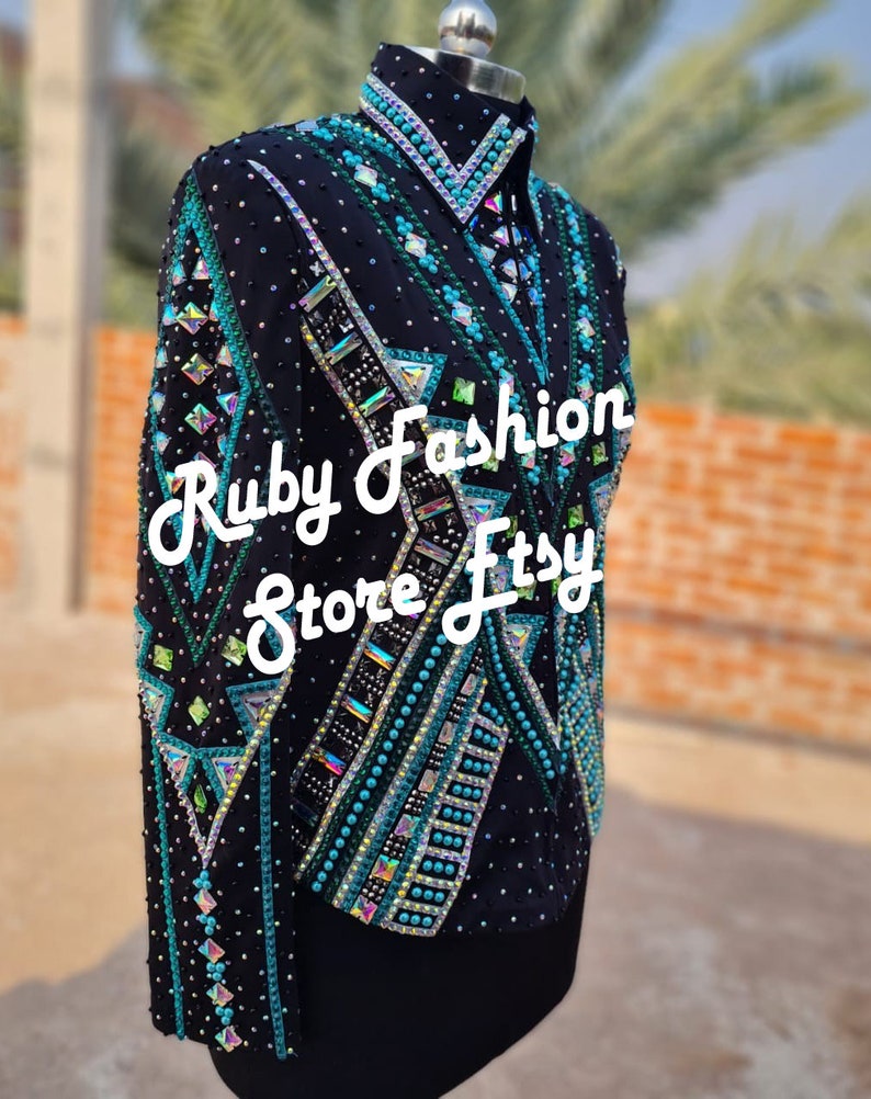 May include: A black long-sleeve jacket featuring intricate geometric patterns in teal, green, and silver. The garment is heavily embellished with various shapes of crystals, beads, and rhinestones. The text Ruby Fashion Store Etsy is overlaid.