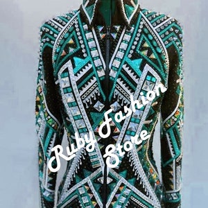 May include: A black long-sleeve jacket featuring intricate aquamarine and silver geometric patterns, embellished with numerous clear crystals and studs. The text "Aquamarine on Black Base" and "Ruby Fashion Store" is overlaid on the image.