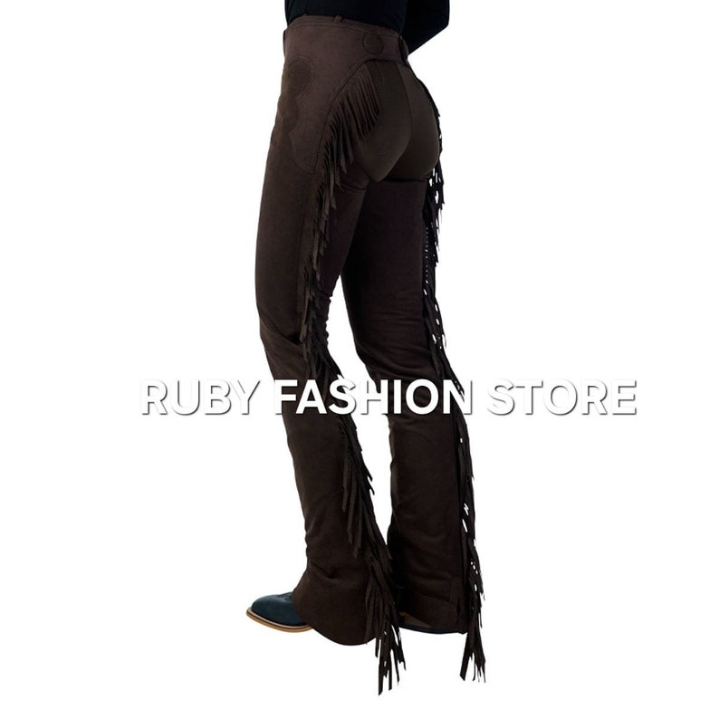 May include: Brown suede pants with fringe detail along the sides. The pants have a slim fit and a straight leg.