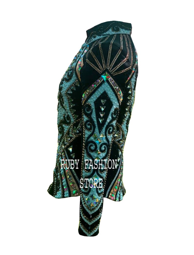 May include: A black long-sleeved shirt featuring intricate light blue patterns, embellished with numerous iridescent crystals and beads. The garment displays the text RUBY FASHION STORE in white lettering on the side, showcasing a high-neck design.