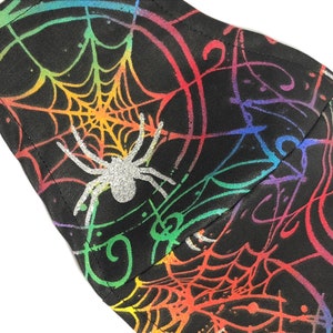 Rainbow colored spider webs with silver glitter spiders face mask for adults and kids. Shine in the Halloween spirit with this webbed mask.