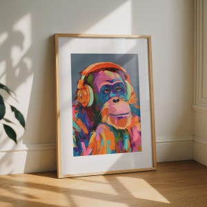 Könnte beinhalten: Ein gerahmter Kunstdruck mit einem lebendigen, mehrfarbigen Ölgemälde eines Orang-Utans, der einen leuchtend orangefarbenen Kopfhörer trägt. Das Kunstwerk verwendet kräftige, ausdrucksstarke Pinselstriche in Blau-, Rosa-, Gelb- und Orangetönen auf grauem Grund.