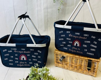 May include: Two navy blue fabric baskets with silver handles. The baskets are filled with names and the text "Wir sagen Dankel" and "Klasse 2a Schuljahr 2023/24". A rainbow with a heart is in the center of each basket.