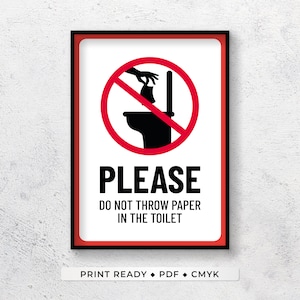 May include: A white sign with a red circle and a diagonal line through it. The circle shows a toilet with a hand dropping paper into it. The text below the circle says "PLEASE DO NOT THROW PAPER IN THE TOILET".