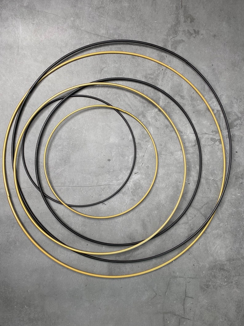May include: Five concentric circles, with the inner three circles being black and the outer two circles being gold.