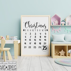 Op de afbeelding: Een witte afdrukbare kerst-aftelposter met zwarte tekst die "Christmas Countdown" en de nummers 1 tot en met 25 zegt. De poster is ingelijst en hangt aan een muur in een kinderkamer.
