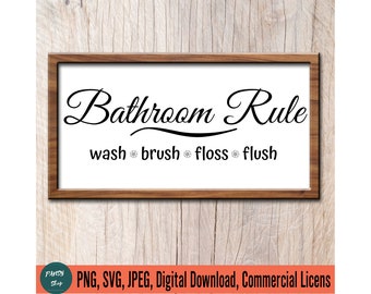 May include: A white sign with a brown wooden frame, featuring the text "Bathroom Rule" in a decorative script font. Below the title, the text "wash brush floss flush" is displayed in a smaller font.