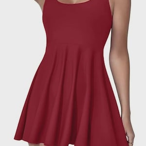 May include: A solid burgundy skater dress with a scoop neckline and thin straps. The dress features a fitted bodice and a flared skirt, creating a flattering silhouette. The fabric appears smooth and has a slight sheen.