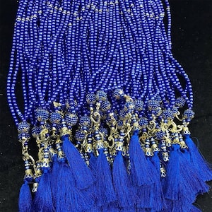 May include: A group of blue prayer beads with gold tassels. Each bead strand has a decorative gold charm and a blue tassel.