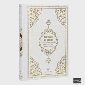 Puede incluir: Un libro blanco con detalles decorativos dorados y texto. La portada presenta patrones dorados ornamentados y el título "AI-QUR'AN AL-KARIM" en letras doradas. El lomo también tiene texto en dorado. El libro está de pie.