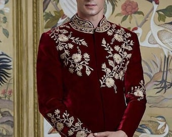 May include: A maroon velvet long-sleeved jacket with gold embroidery of floral designs. The jacket has a mandarin collar and a front closure.