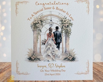 Puede incluir: Tarjeta de boda con una ilustración en acuarela de una novia y un novio caminando hacia un arco floral. La tarjeta dice "Felicitaciones a una hermana y cuñado especiales" e incluye los nombres "Imogen & Stephen" y la fecha "23 de abril de 2026".
