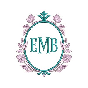 May include: An oval-shaped floral monogram design with the letters "EMB" in teal. The frame is teal with a scalloped edge, adorned with pink flowers and leaves. The design is set against a white background.
