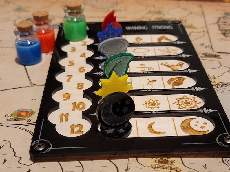 May include: A board game with a black frame and wooden accents. The board features numbered slots and symbols. Colorful potion bottles and game pieces, including a sun, moon, and leaf, are placed on the board. The text "WANING STRONG" is visible.