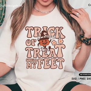 May include: A white t-shirt with a retro-style graphic design that says "Trick or Treat Smell My Feet" with a cartoon pumpkin character holding a wand.