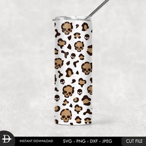 May include: A white tumbler with a brown and black leopard print and skull design. The tumbler has a straw.