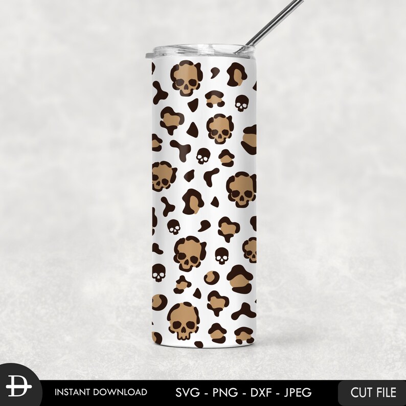 May include: A white tumbler with a brown and black leopard print and skull design. The tumbler has a straw.