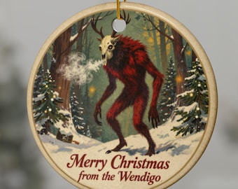 Puede incluir: Adorno navideño redondo con un Wendigo rojo en una escena de bosque nevado. El Wendigo tiene cuernos y exhala. El texto "Merry Christmas from the Wendigo" está impreso en la parte inferior. El adorno cuelga de un hilo dorado.