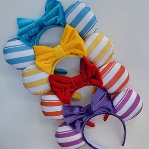 May include: Set of six colorful striped fabric headbands with velvet bows. Each headband features a different color stripe pattern and a matching velvet bow.