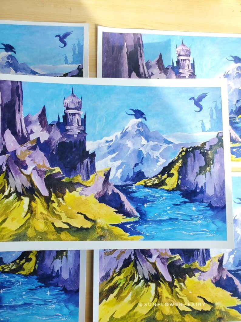 Puede incluir: Impresiones art&iacute;sticas de acuarela que representan una escena de fantas&iacute;a con dragones, monta&ntilde;as y un castillo. La obra de arte utiliza tonos de azul, morado y amarillo. Las impresiones tienen un cielo azul claro y un r&iacute;o.