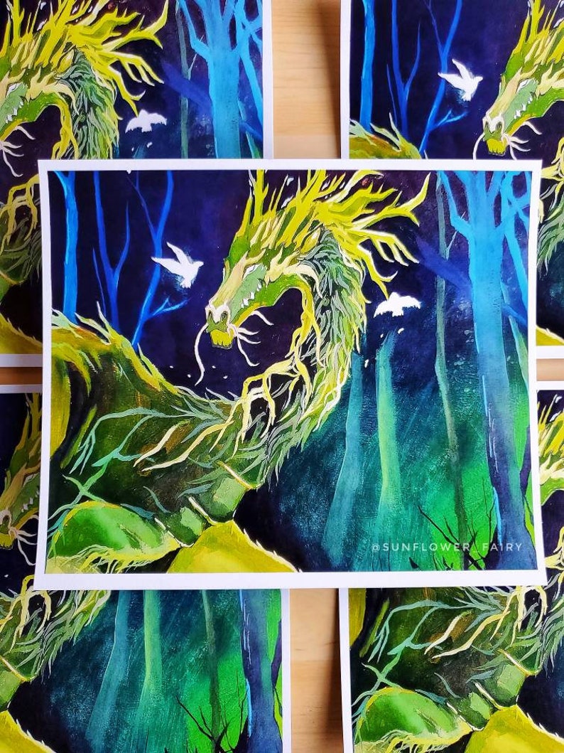 May include: Watercolor painting of a green and yellow dragon in a forest setting with blue trees and white birds. The artwork has a fantasy theme and is signed with the text "#SUNFLOWER FAIRY".