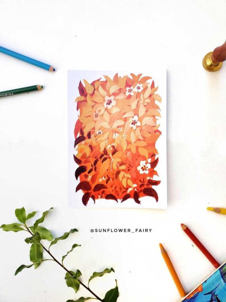 May include: An artwork featuring a vibrant floral arrangement in shades of orange, yellow, and red, with small white flowers. The painting is on a white background, surrounded by colored pencils, a sprig of leaves, and a gold wax seal.